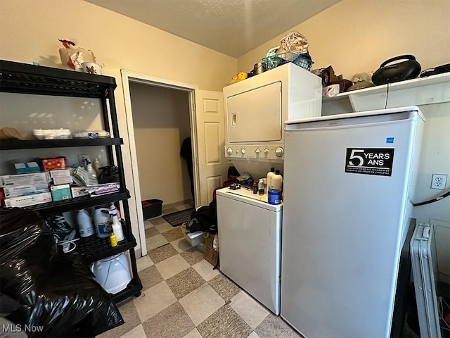 laundry area with light floors, stacked washing maching and dryer, and laundry area