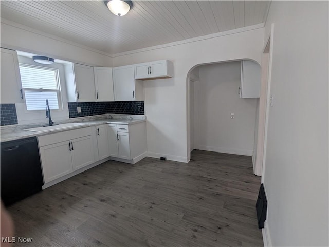 kitchen with arched walkways, a sink, white cabinetry, light countertops, and dishwasher