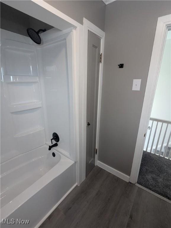 full bath featuring tub / shower combination, baseboards, and wood finished floors