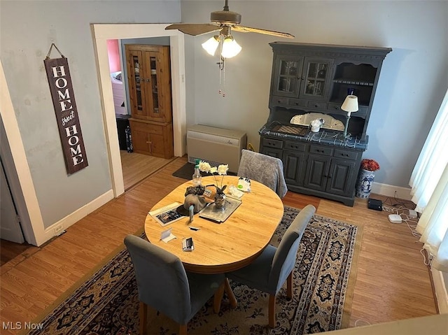 dining area featuring baseboards, ceiling fan, and light wood-style floors