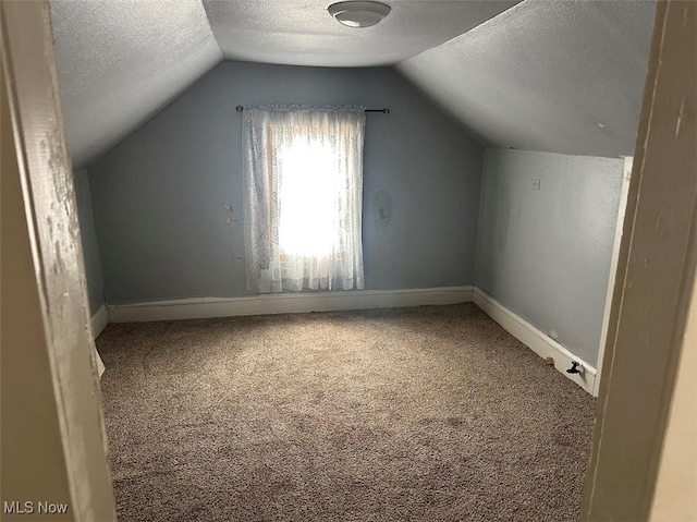 bonus room with lofted ceiling, carpet flooring, a textured ceiling, and baseboards