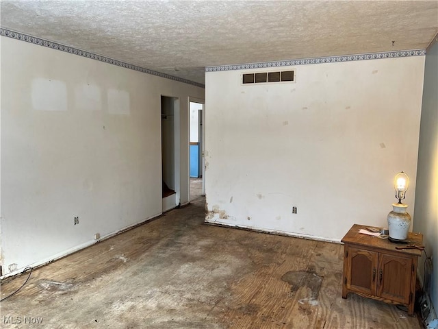 empty room with visible vents and a textured ceiling