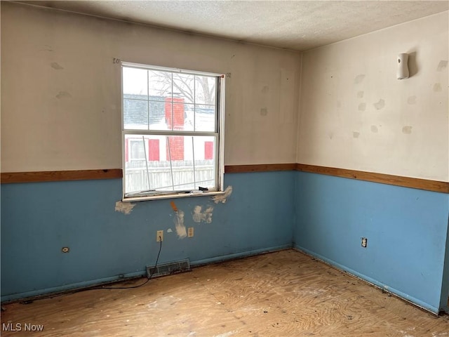 spare room featuring a textured ceiling and visible vents