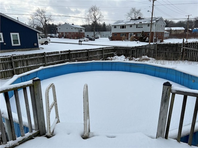 snow covered pool with fence and a fenced in pool