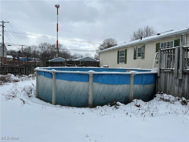 snow covered pool with fence and a fenced in pool