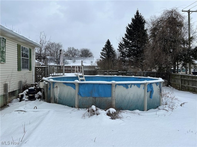 snow covered pool with a fenced backyard and a fenced in pool