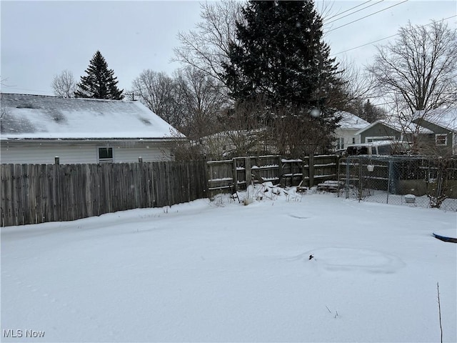 yard covered in snow with fence