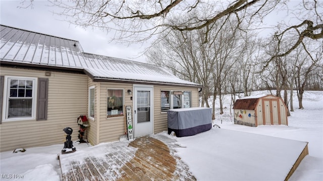 view of front of property with metal roof, an outdoor structure, a standing seam roof, and a storage unit