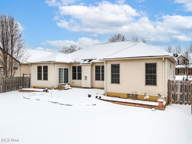 snow covered property featuring entry steps and fence