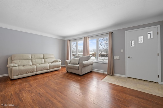 living room featuring a baseboard radiator, a textured ceiling, baseboards, and wood finished floors