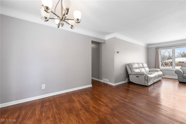 interior space with dark wood-type flooring, a chandelier, visible vents, and baseboards