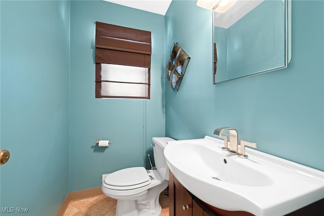 bathroom with toilet, tile patterned floors, baseboards, and vanity