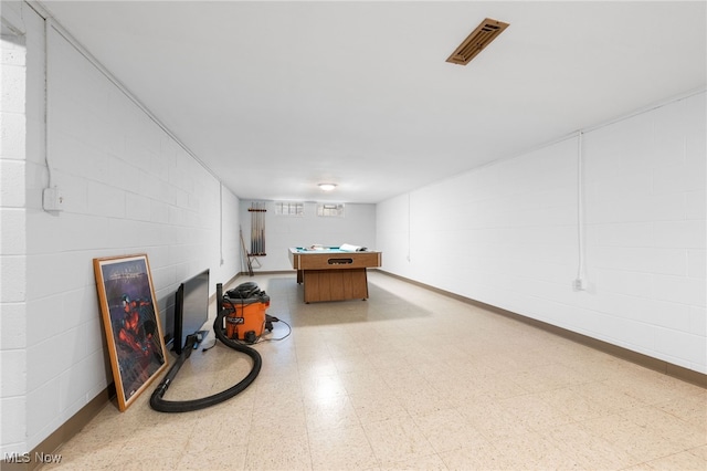 game room featuring concrete block wall, baseboards, visible vents, light floors, and a fireplace