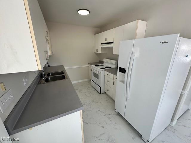 kitchen featuring under cabinet range hood, white appliances, a sink, white cabinetry, and marble finish floor