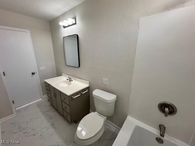 bathroom with marble finish floor, a textured wall, toilet, vanity, and baseboards