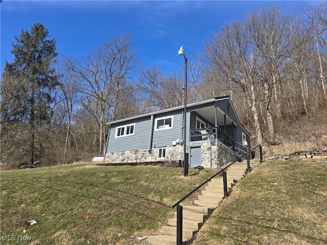 view of front of house with stairway and a front lawn