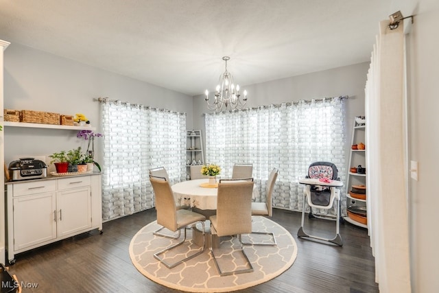 dining area with a chandelier and dark wood finished floors