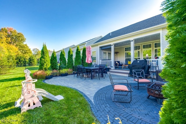 view of patio with an outdoor fire pit and fence