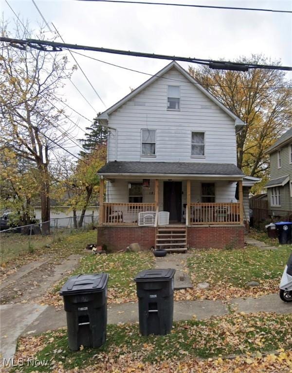 view of front of property featuring a porch and fence
