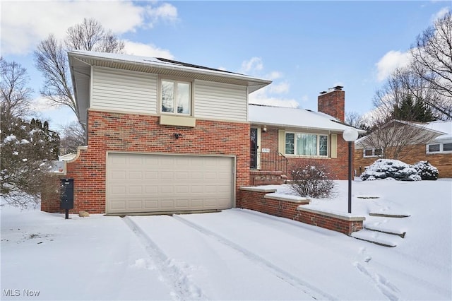 tri-level home with brick siding, a chimney, and an attached garage