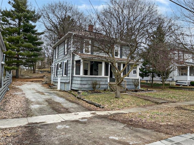 american foursquare style home featuring driveway and a chimney