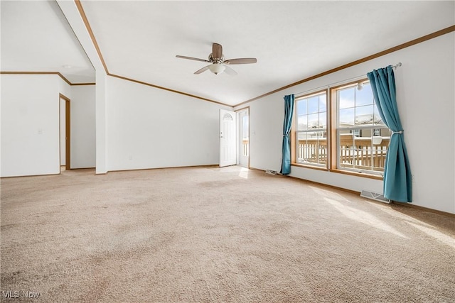 carpeted empty room featuring ceiling fan, crown molding, visible vents, and baseboards