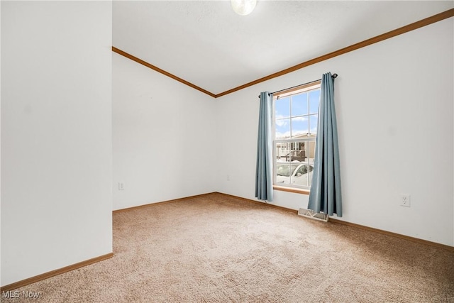 unfurnished room with ornamental molding, carpet flooring, and baseboards