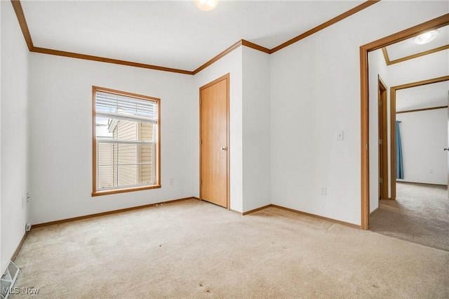 unfurnished bedroom with baseboards, crown molding, visible vents, and light colored carpet