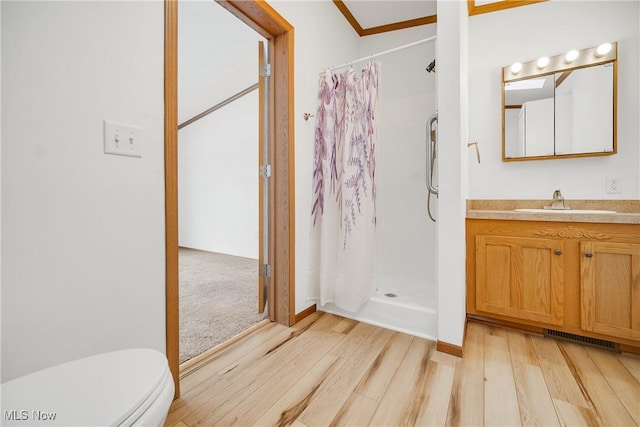 bathroom with vanity, wood finished floors, visible vents, and a shower stall