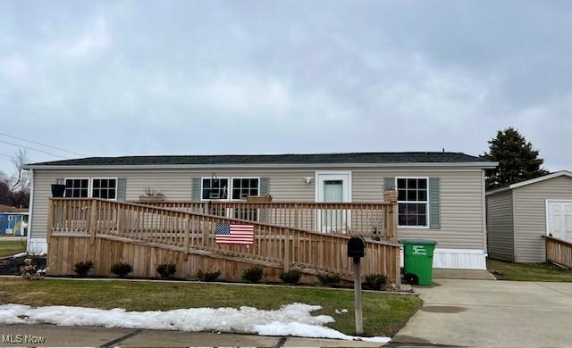 manufactured / mobile home featuring a deck and a front yard