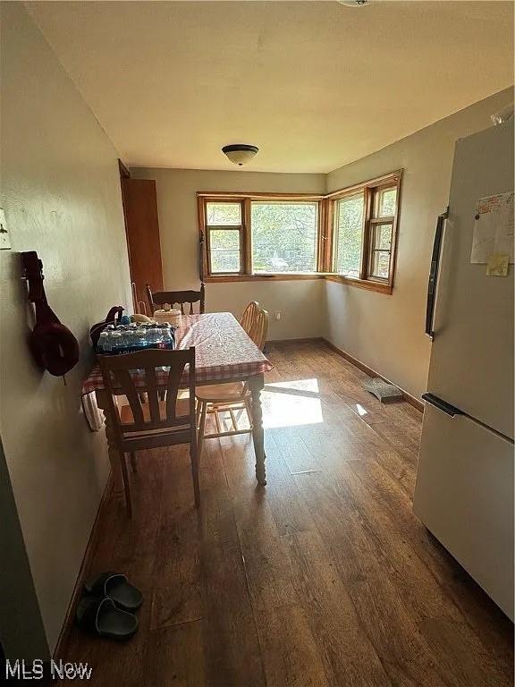 dining room with a healthy amount of sunlight, baseboards, and wood finished floors