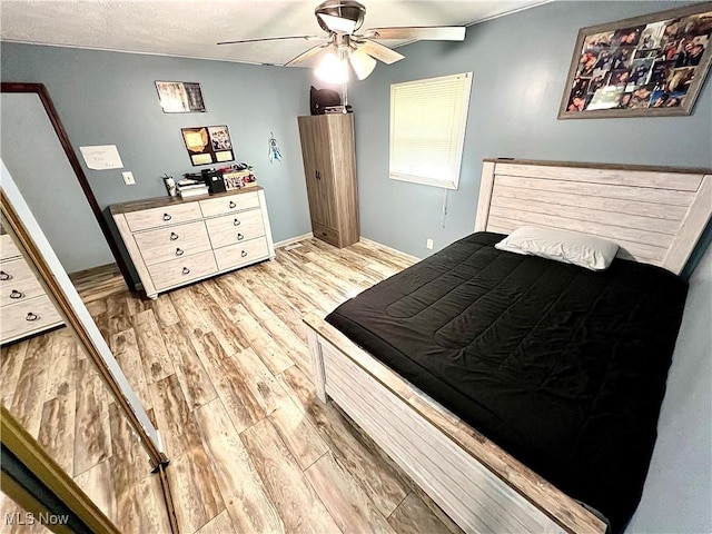 bedroom with light wood-style floors and a ceiling fan