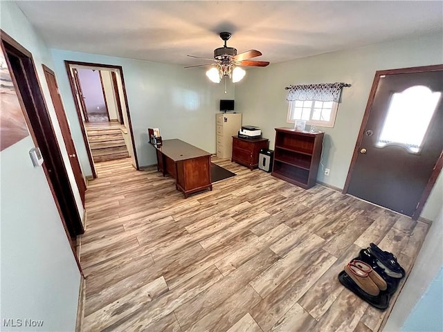 home office with light wood-type flooring and ceiling fan