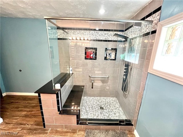 bathroom featuring a shower stall, baseboards, and wood finished floors