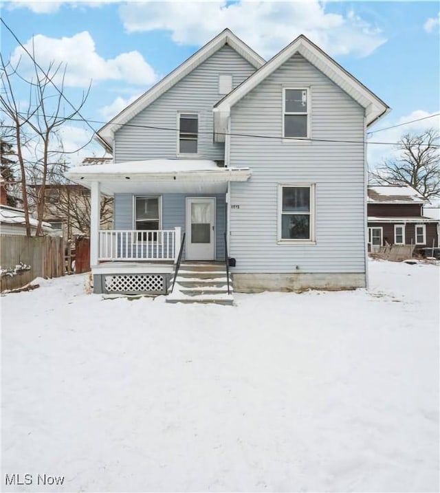 snow covered property with a porch