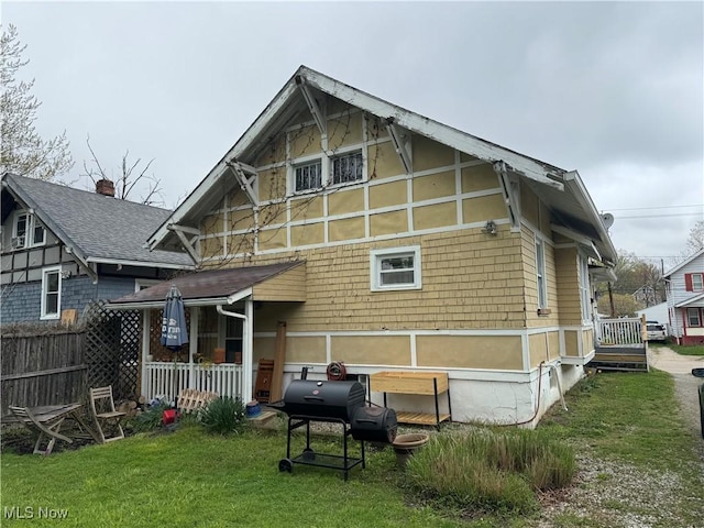 rear view of property with fence and a lawn