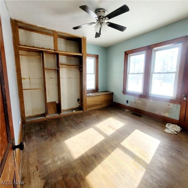 unfurnished bedroom featuring a ceiling fan, dark wood finished floors, visible vents, and baseboards