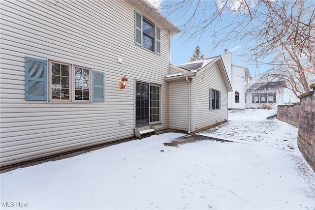 snow covered property with fence