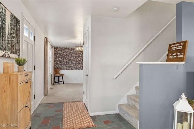 stairway with stone finish flooring, carpet, and baseboards