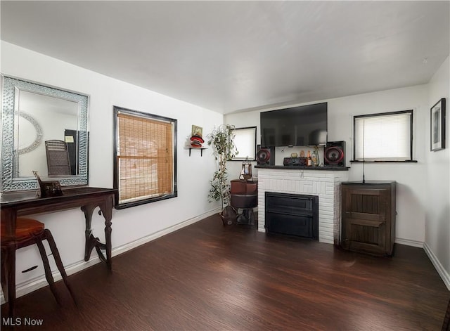 living area featuring dark wood-style floors, a fireplace, and baseboards