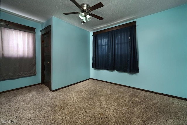 carpeted empty room with a ceiling fan, a textured ceiling, and baseboards