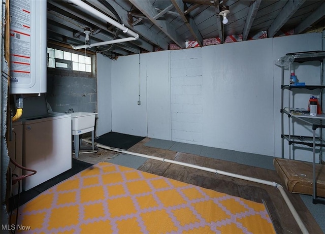 below grade area featuring water heater, washer / clothes dryer, and a sink