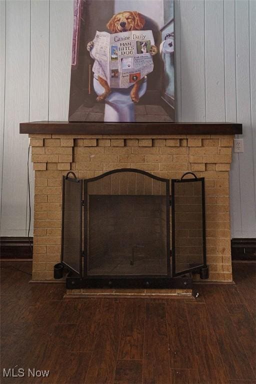 interior details featuring a brick fireplace and wood finished floors