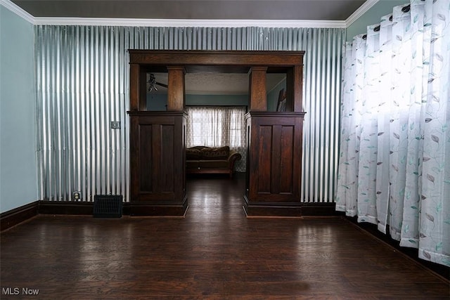 spare room featuring baseboards, ornamental molding, and dark wood-style flooring