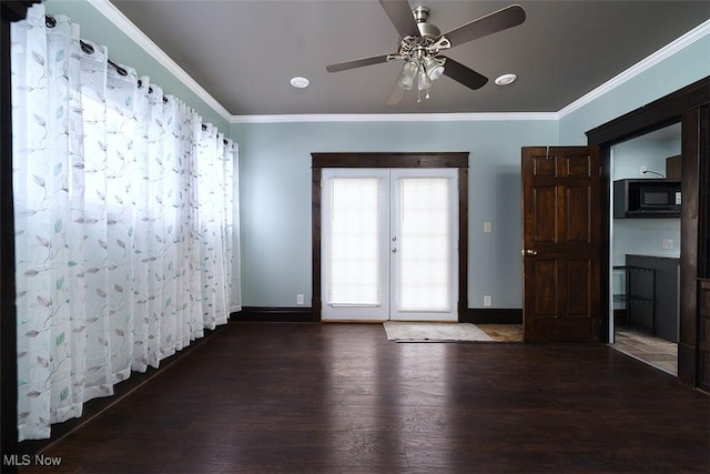 spare room featuring baseboards, dark wood finished floors, crown molding, and french doors