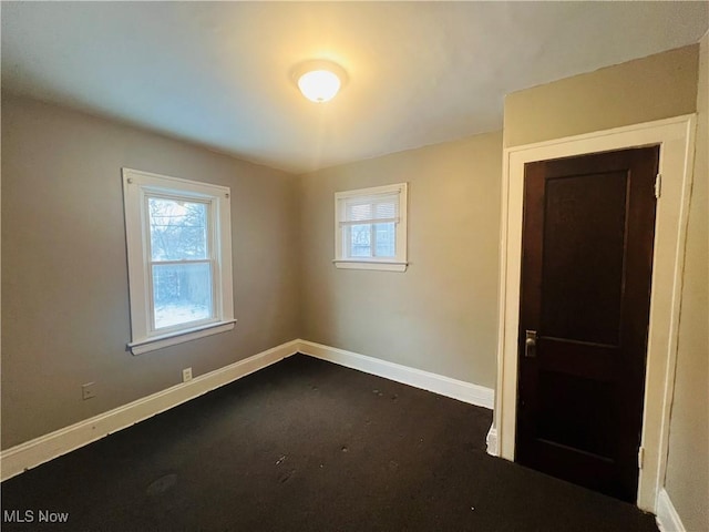 empty room featuring a wealth of natural light and baseboards