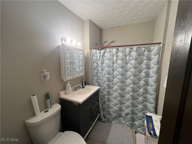 full bathroom with toilet, a tile shower, vanity, and a textured ceiling