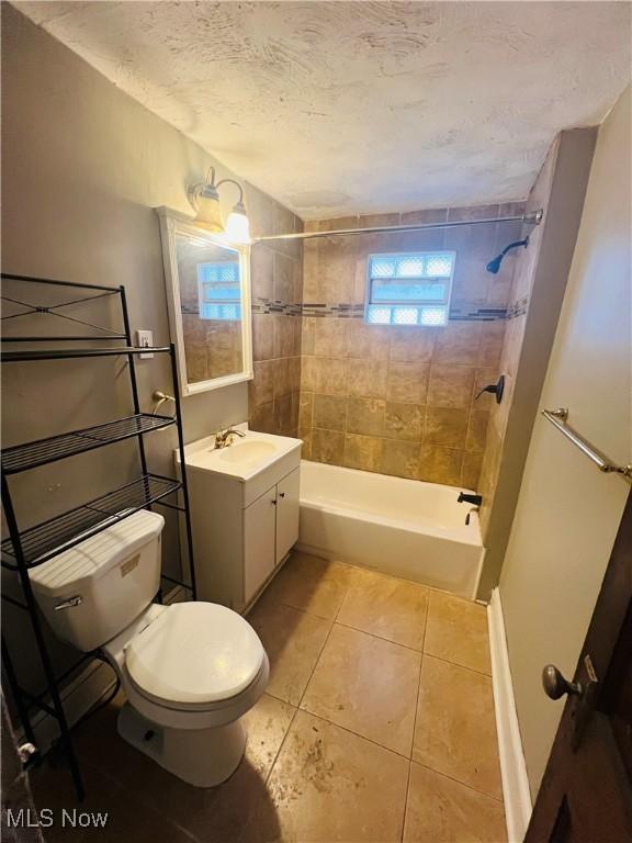 bathroom with toilet, tile patterned flooring, a textured ceiling, vanity, and shower / bathing tub combination