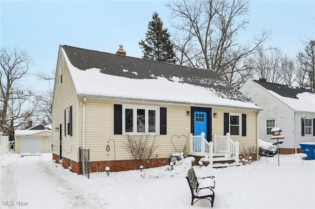 view of front of home featuring a detached garage, a chimney, and an outdoor structure