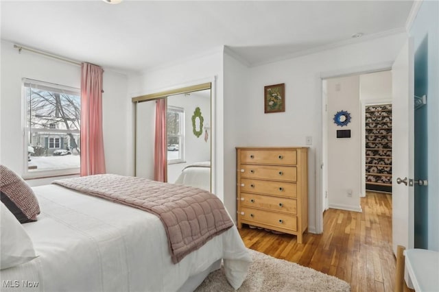 bedroom featuring ornamental molding, a closet, and wood finished floors